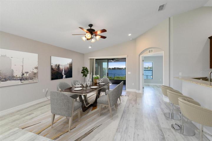 This photo has been virtually staged. Open the sliding glass doors from the dining area, and you'll find yourself on the screened lanai, where you can savor the breathtaking views of Lake Sears.