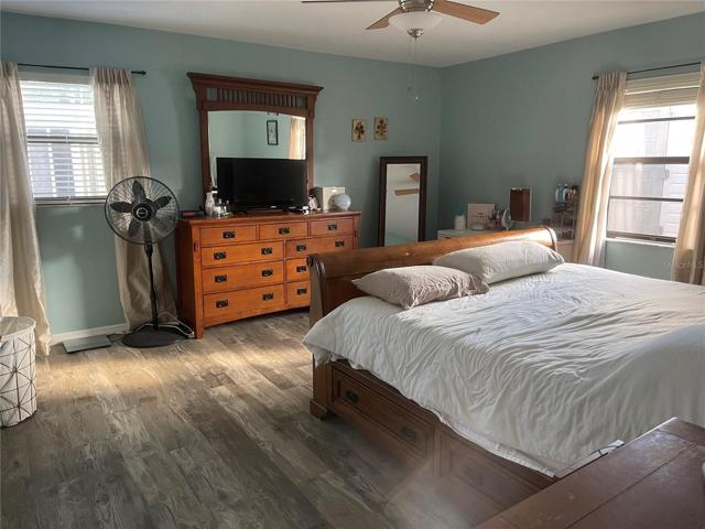 Large Master Bedroom with ceiling fan and Laminate Flooring