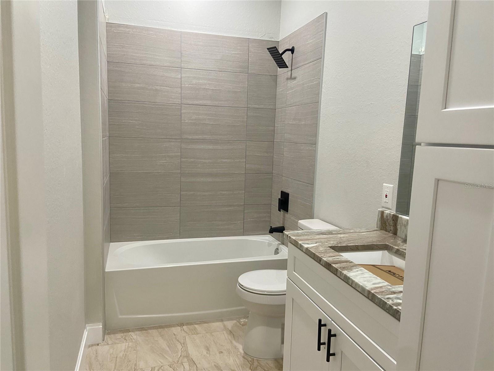 Hall bath with tiled shower/tub combo