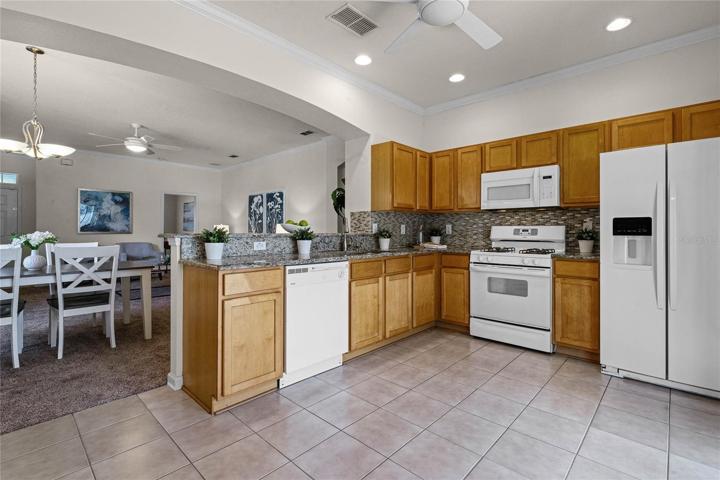 Kitchen w/ granite countertops, Listello tile backsplash & crown molding