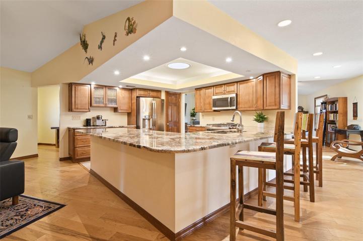 The kitchen is nestled in the heart of the home, showcasing and array of features that include a wrap around breakfast bar, GRANITE COUNTERS, beautifully crafted SOLID WOOD CABINETS, STAINLESS STEEL APPLIANCES (including a GAS RANGE!) and a large pantry for ample storage!