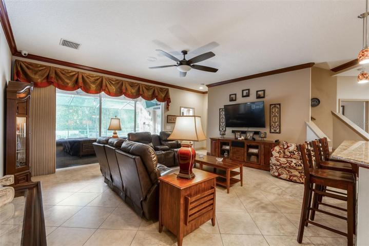 The family room overlooks oversized stacking  triple sliders. Deep conservation views are enjoyed inside and outside of this turn key beauty of a home.