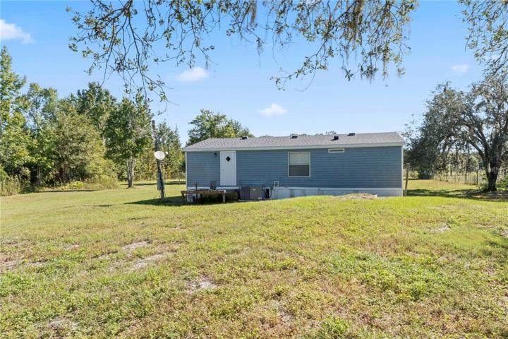 Rear of home, near tree line.