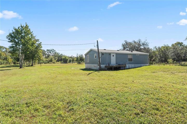 Rear of home, near tree line.