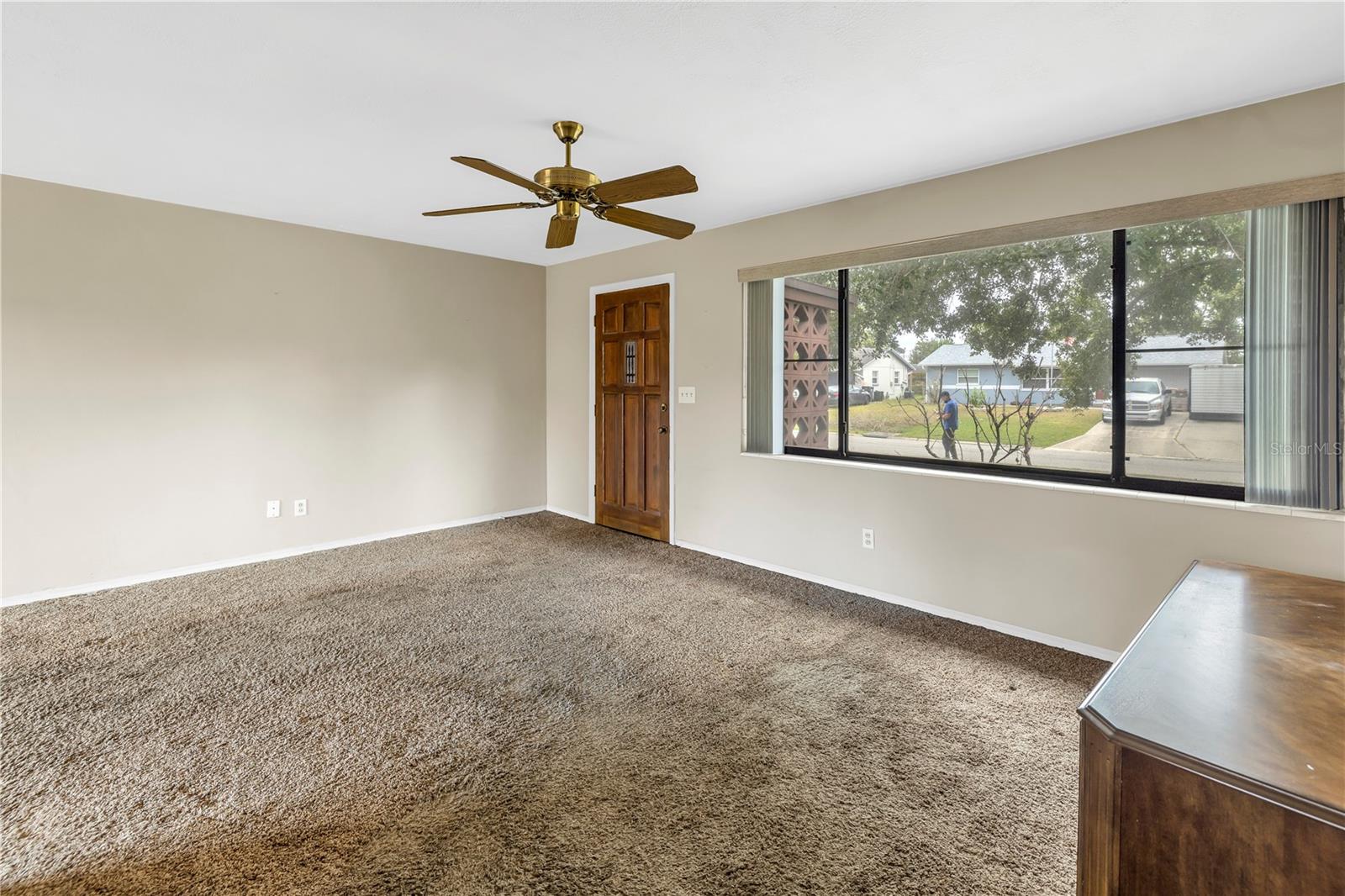 Beautiful wall of windows overlooking the front yard with blinds for privacy