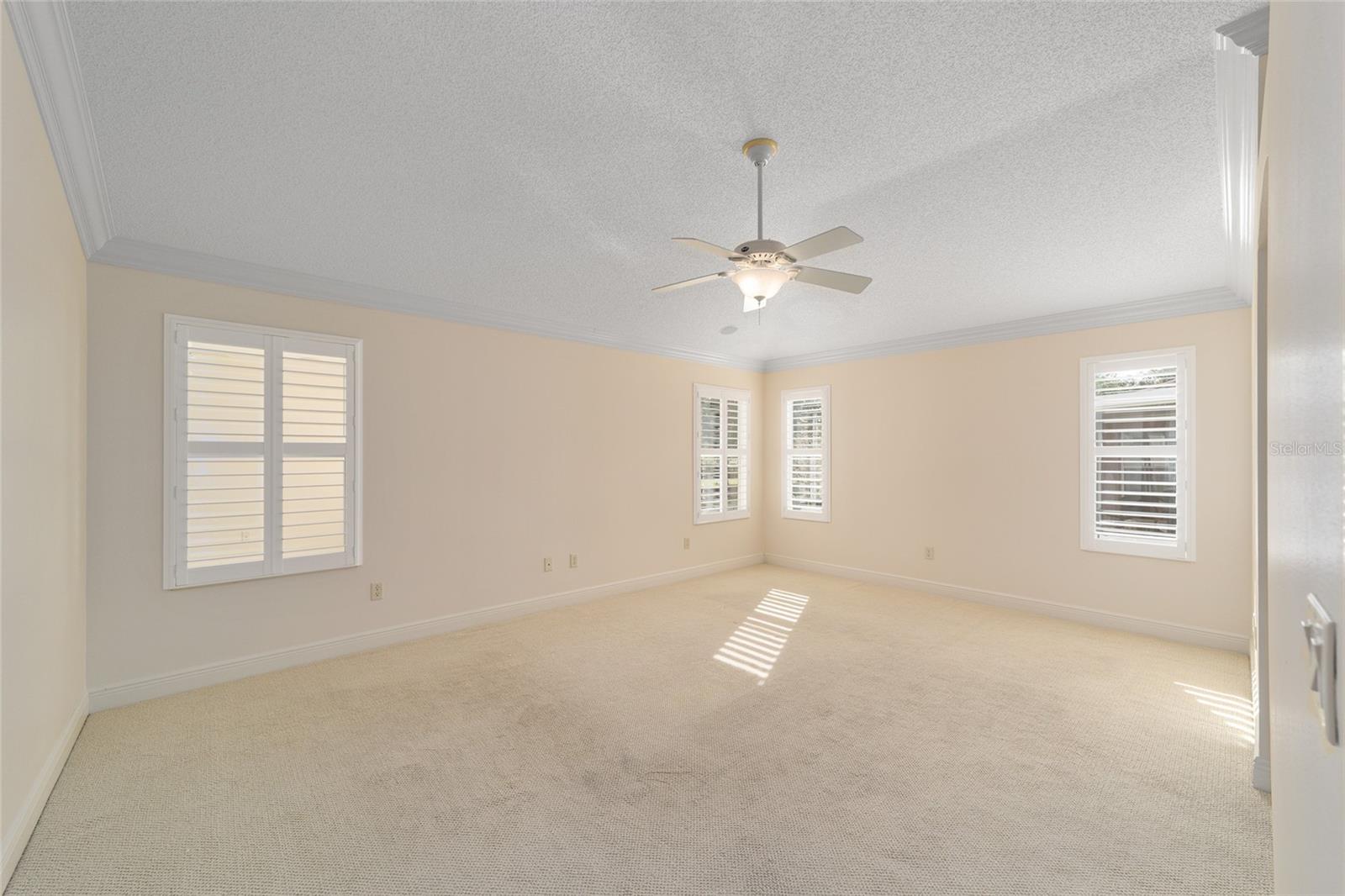 Primary bedroom with lots of windows and Plantation shutters