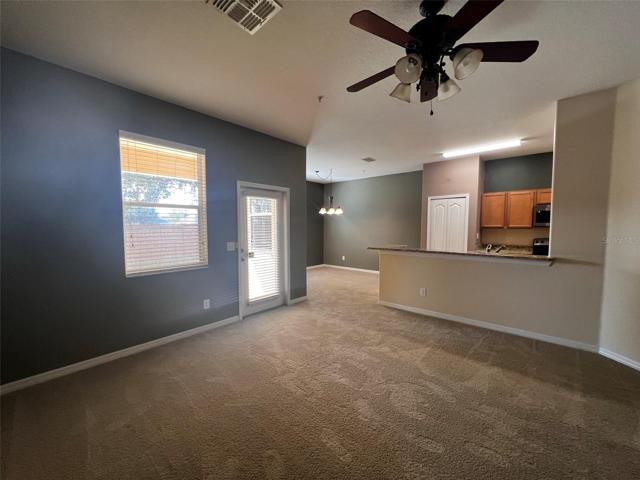 Living room to private patio, kitchen, and dining