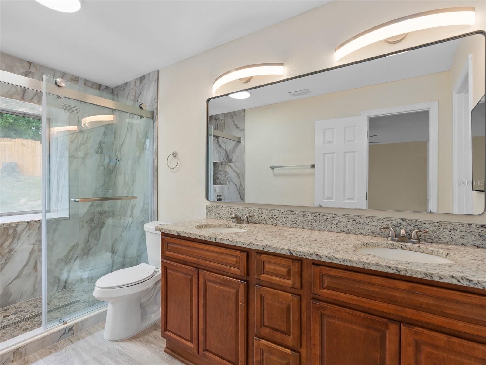 master bathroom with upgraded fixtures, his hers dual under mount sinks and granite countertop