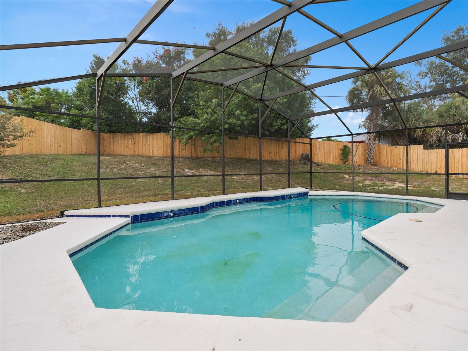 screened in large pool with newly fenced in backyard.