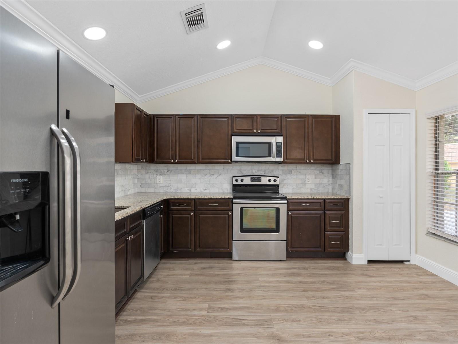 kitchen with granite countertops, upgraded kitchen cabinets and stainless steel appliances
