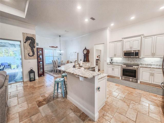Open kitchen with Custom Cabinetry and Designer Backsplash and  Granite Counter-tops.