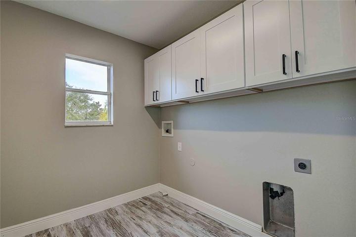Second level laundry room with NEW overhead storage cabinets.