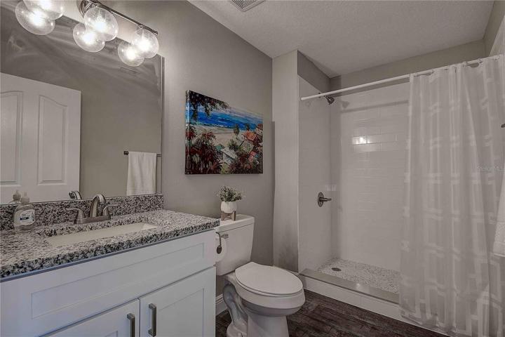 Main full bath located on the first level.  All new tile shower, new bath cabinets, granite countertops and modern lighting!
