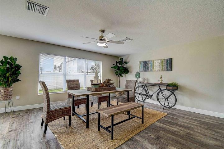 Dining area overlooks outdoor fully fenced backyard.