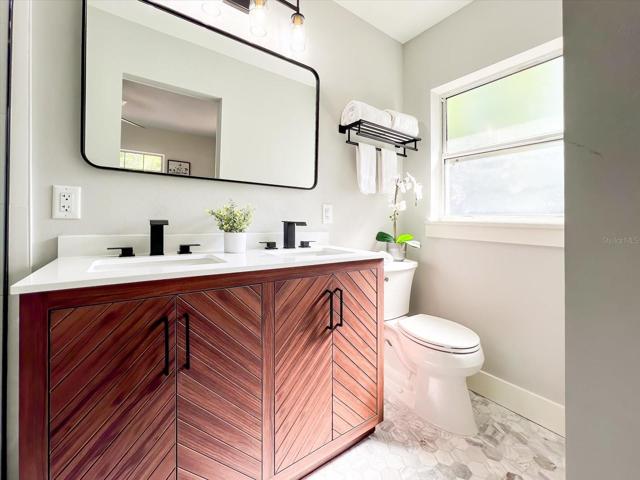 Primary bathroom with double sink vanity and waterfall faucets.