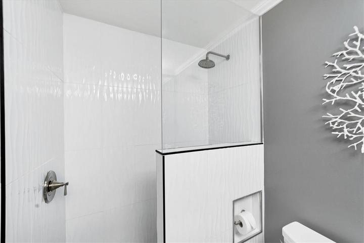Guest shower with crown molding and floor to ceiling tile in the shower