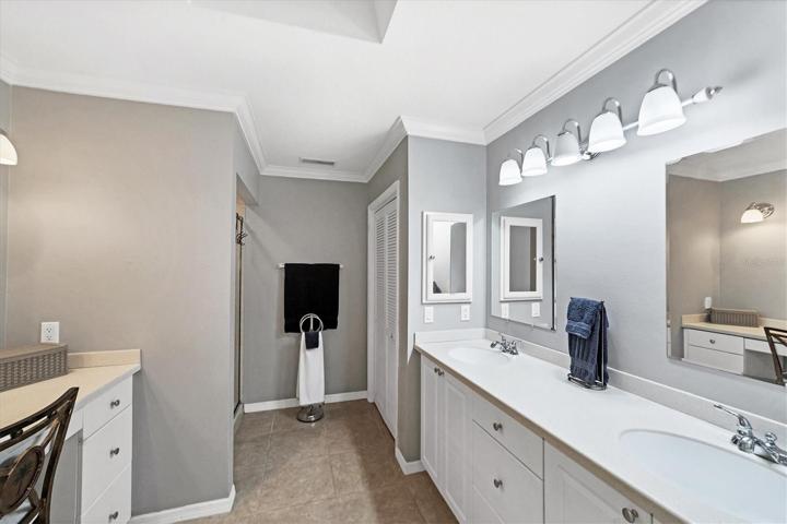 Master bath has crown molding, dual sinks, linen closet, shower and vanity desk