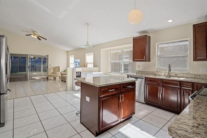 Kitchen is open to the large Family Room. Showcasing vaulted ceilings and natural light. Family room leads to a very large Florida Room.
