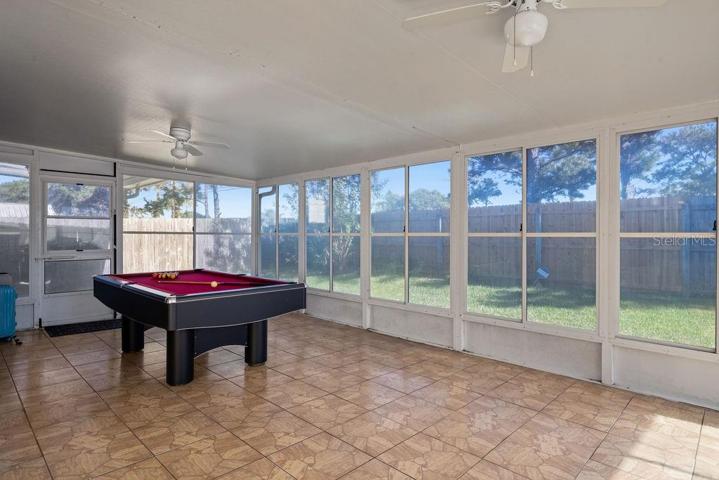 Expansive Florida Room with view of the fenced backyard. Extend your entertainment space and use your imagination for this room - games, exercise, crafts, lounging, social area.