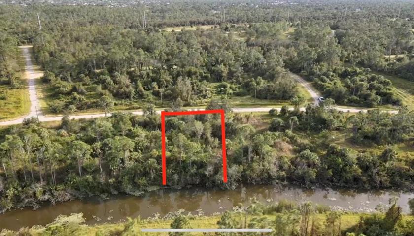 Zoomed out back aerial view of property.