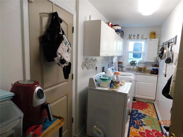 spacious laundry/utility room with cabinets & counter space