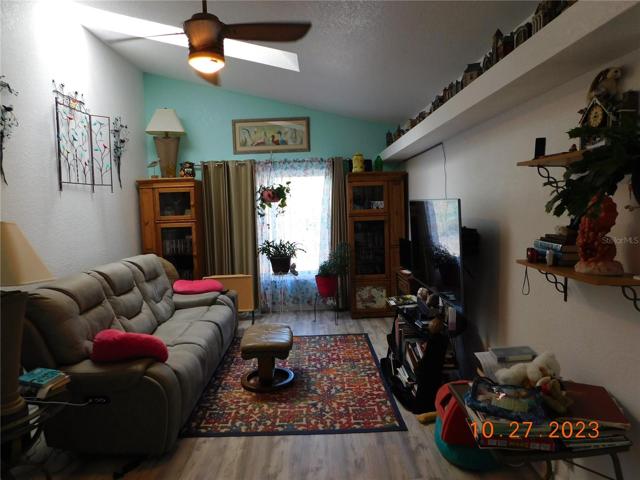 family room with vaulted ceiling, skylight, and built-in shelf