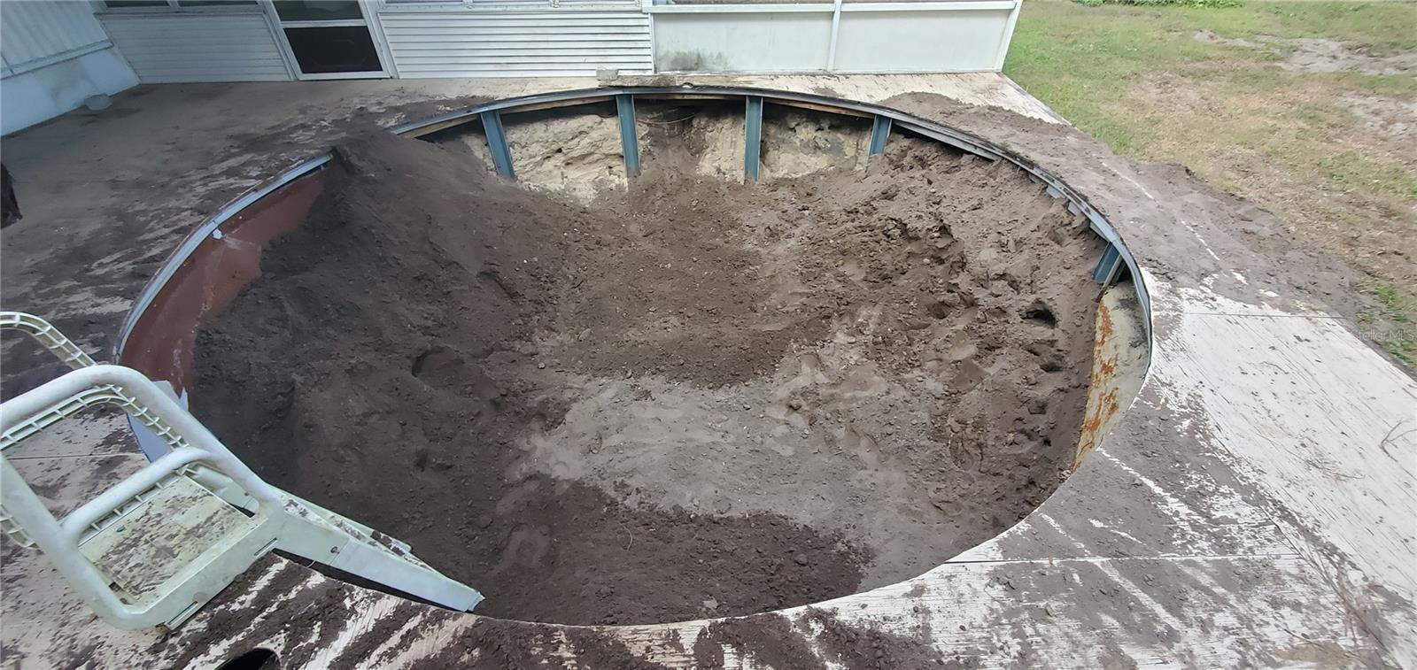 The pool is being filled in with dirt.