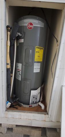 water heater is located within a panel on the side of the house.