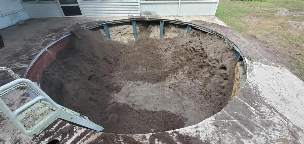 The pool is being filled in with dirt.