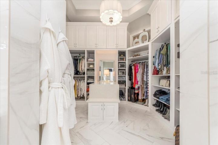 FABULOUS MASTER BEDROOM WALK IN CLOSET WITH EXTENSIVE CABINETRY AND BUILT INS.