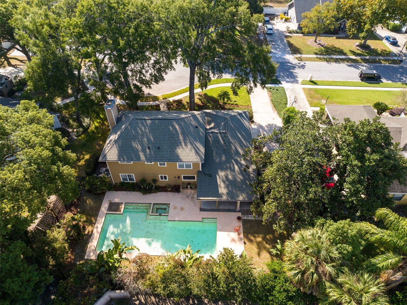 A soaring aerial view of the pool and back of the home.