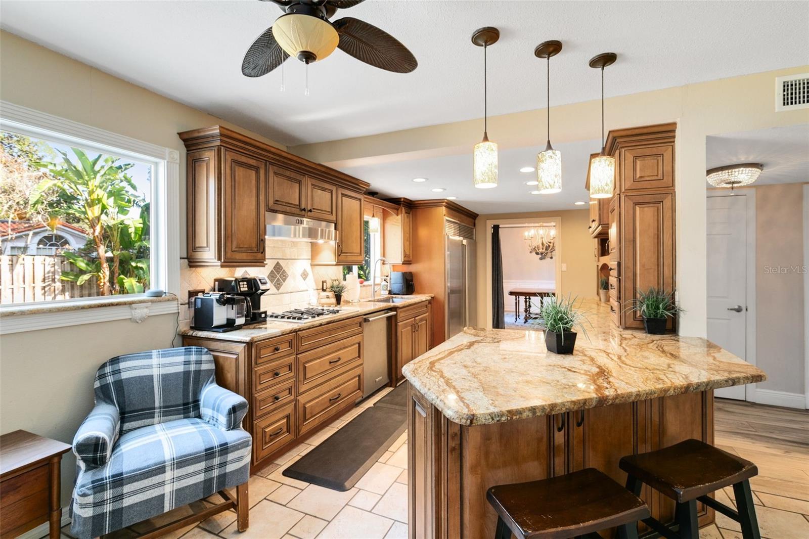 The kitchen is a chef's dream, boasting granite countertops, a convenient breakfast bar, and sleek soft-close cabinets.