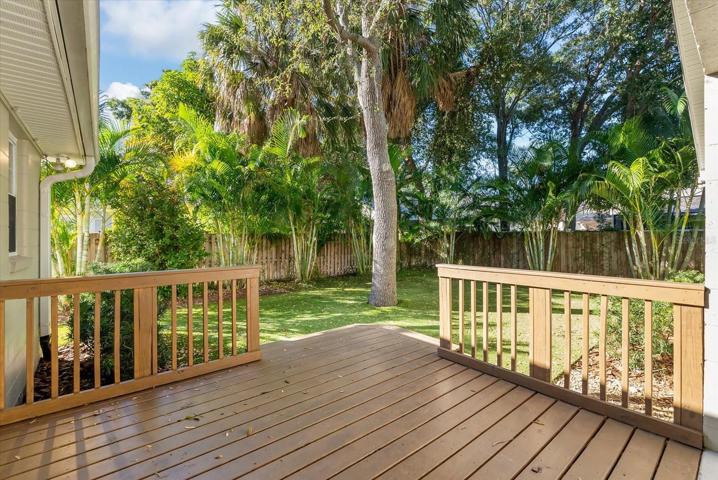 Enjoy the shade on the wood deck overlooking the back yard