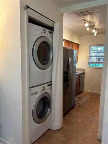Stacked, full-size washer &amp; dryer in kitchen.