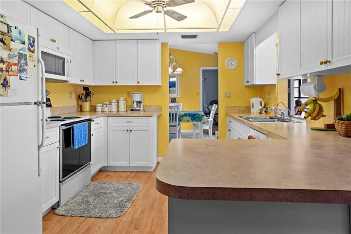 The Kitchen has access to multiple areas in the home:  the Dining Room, the Family/TV Room, and pass-through windows for serving guests into the Lanai and Family Room.