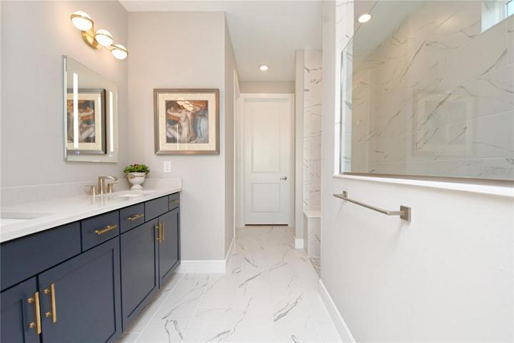 The primary ensuite features dual sinks and stone countertops with high-end cabinetry and hardware.