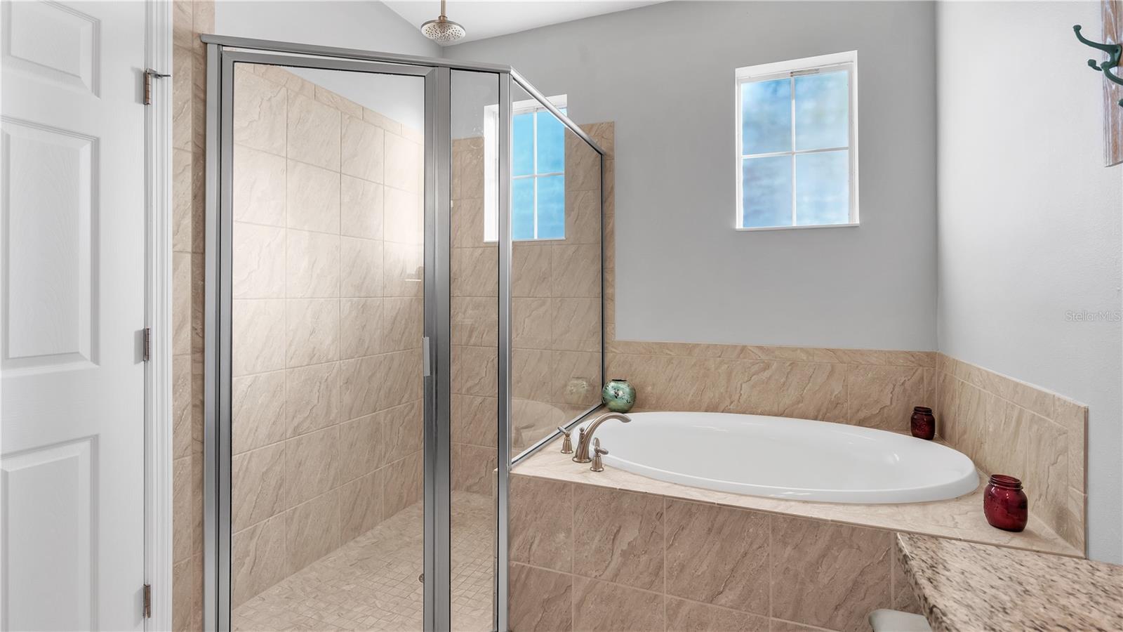 The private master suite features a large bedroom and includes a private ensuite bathroom with upgraded taller double vanities, soaking tub, and spacious walk-in shower, linen closet, and a separate toilet room.