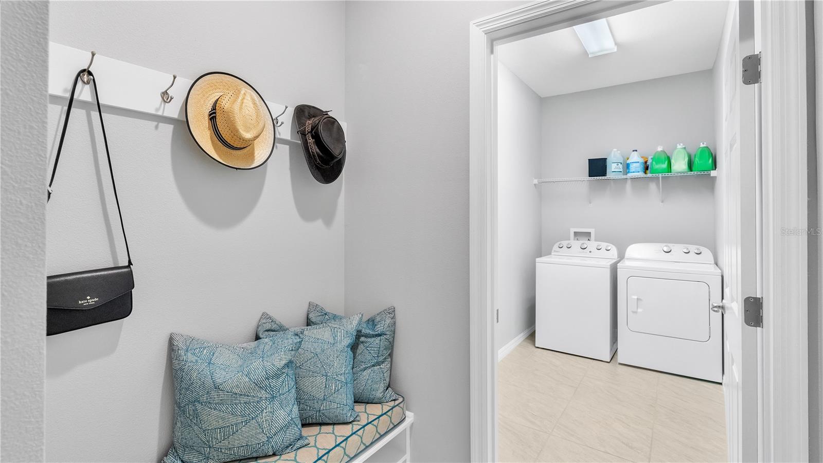 Located near the garage entry door is a perfectly placed drop zone with built-in bench, custom cushion, and hooks for all your bags and hats. In this hallway is also a coat closet and laundry room.
