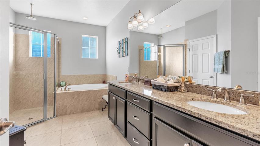 The private master suite features a large bedroom and includes a private ensuite bathroom with upgraded taller double vanities, soaking tub, and spacious walk-in shower, linen closet, and a separate toilet room.