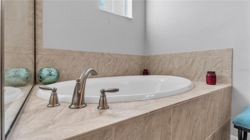 The private master suite features a large bedroom and includes a private ensuite bathroom with upgraded taller double vanities, soaking tub, and spacious walk-in shower, linen closet, and a separate toilet room.