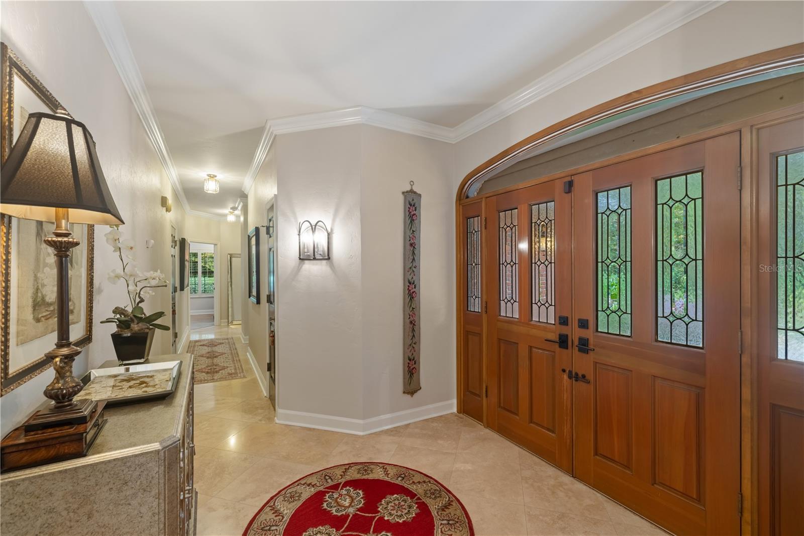 foyer with double wood entry doors and polished travertine flooring