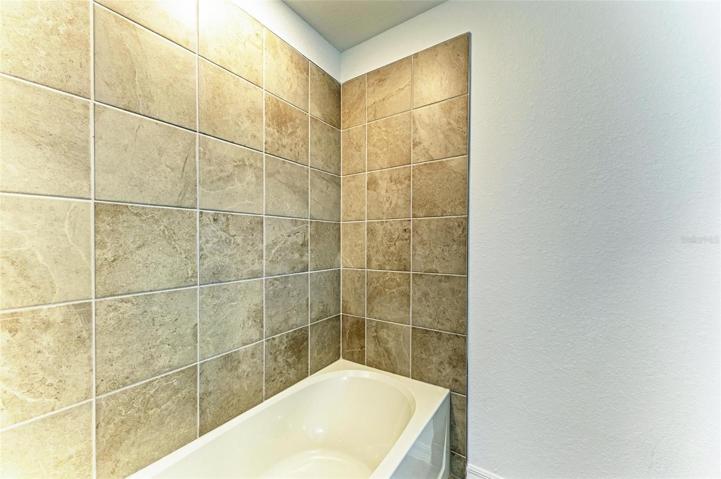 Tiled bath tub in secondary bathroom