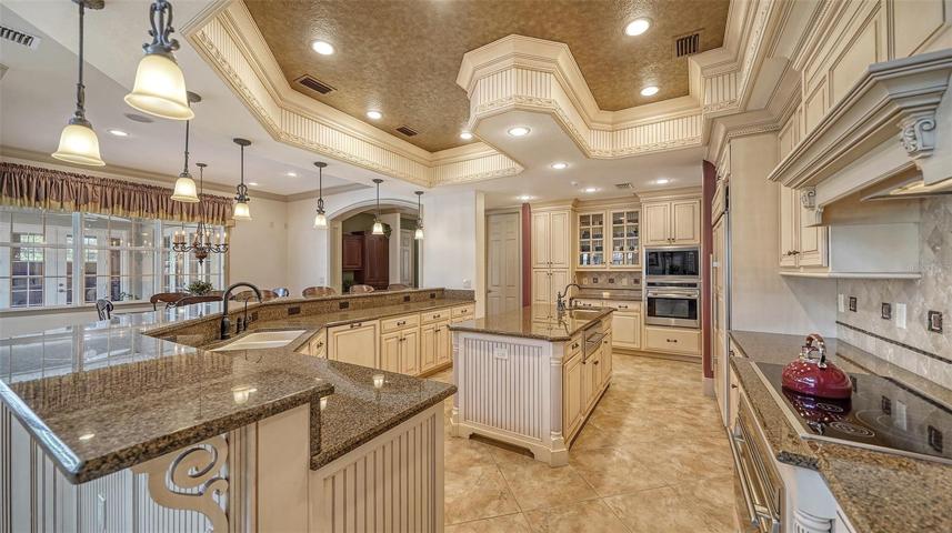 The deluxe chef’s kitchen with designer lighting and tray ceiling.