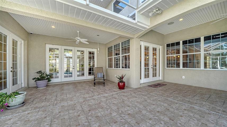 Covered lanai with multiple dining and lounging areas.