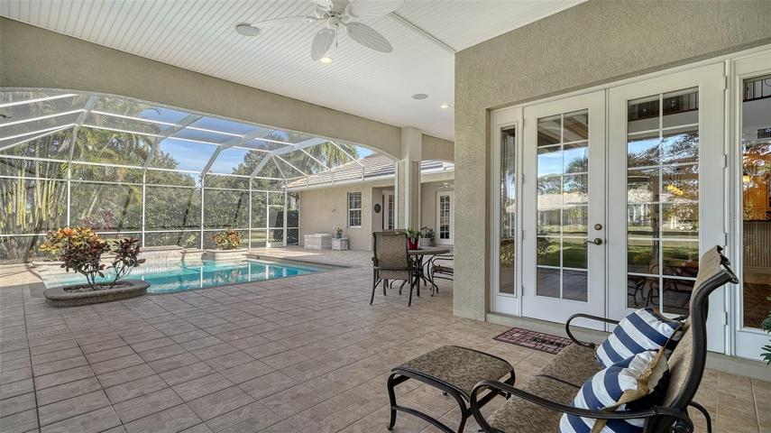 Covered lanai with multiple dining and lounging areas.
