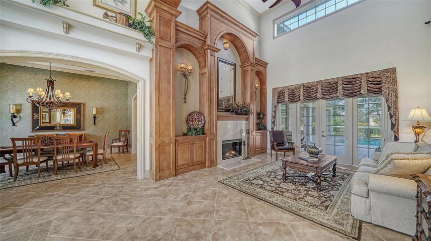 The foyer with soaring 23' ceiling and adjacent inviting living room and dining room.