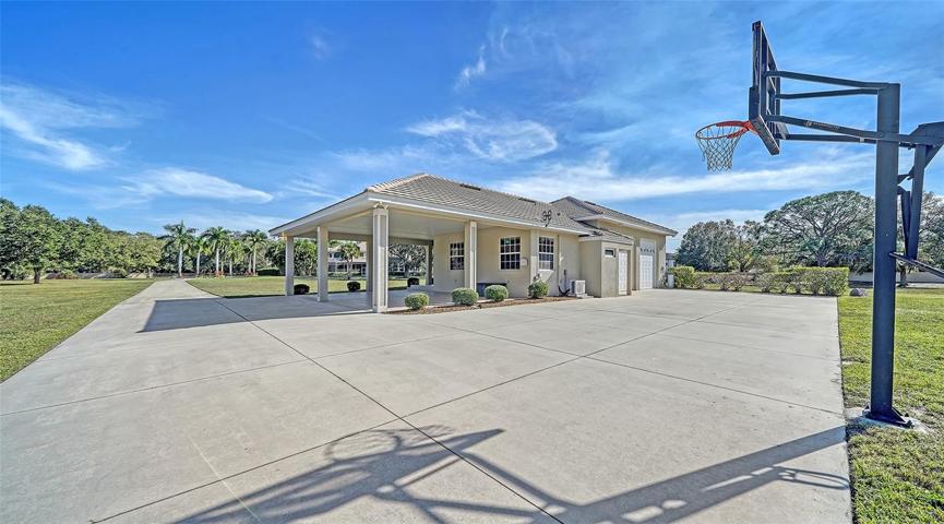 The detached private guest cottage with basketball court and carport for additional parking.
