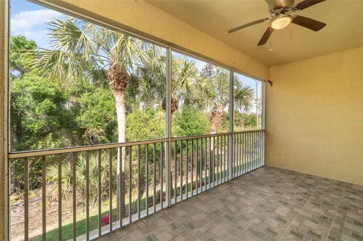 A screened-in balcony offers a tranquil view of the lush private preserve, equipped with a fan and light for an added breeze and illumination during relaxation or evening use.