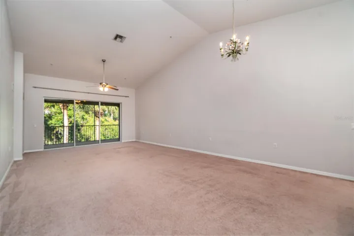 Large sliding glass doors usher in abundant natural light, complemented by the expansive height of the ceilings.
