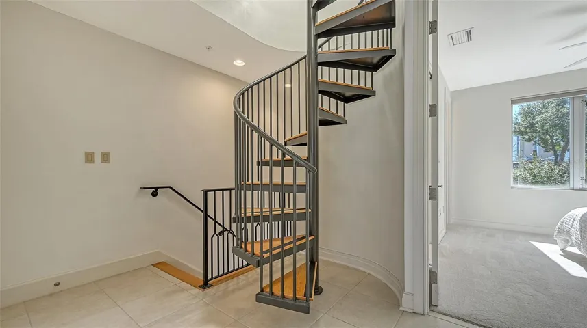 Spiral staircase to Bonus room. Room is virtually staged.